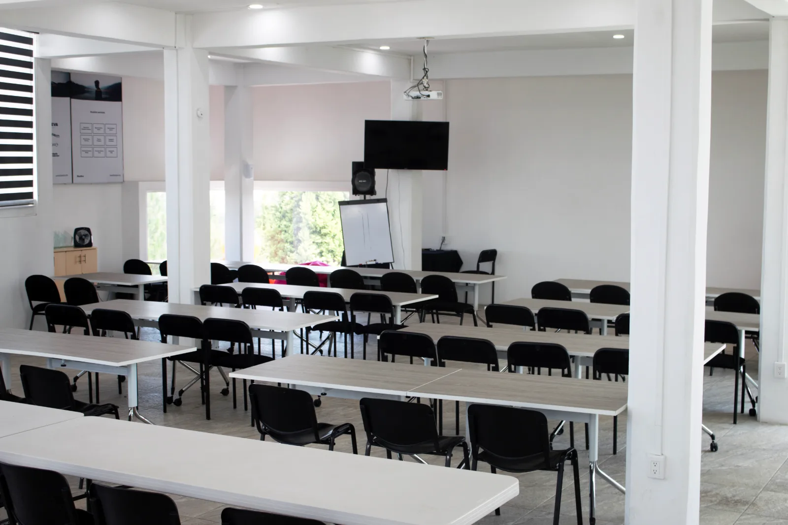 Aula magna con butacas y pantalla de proyección