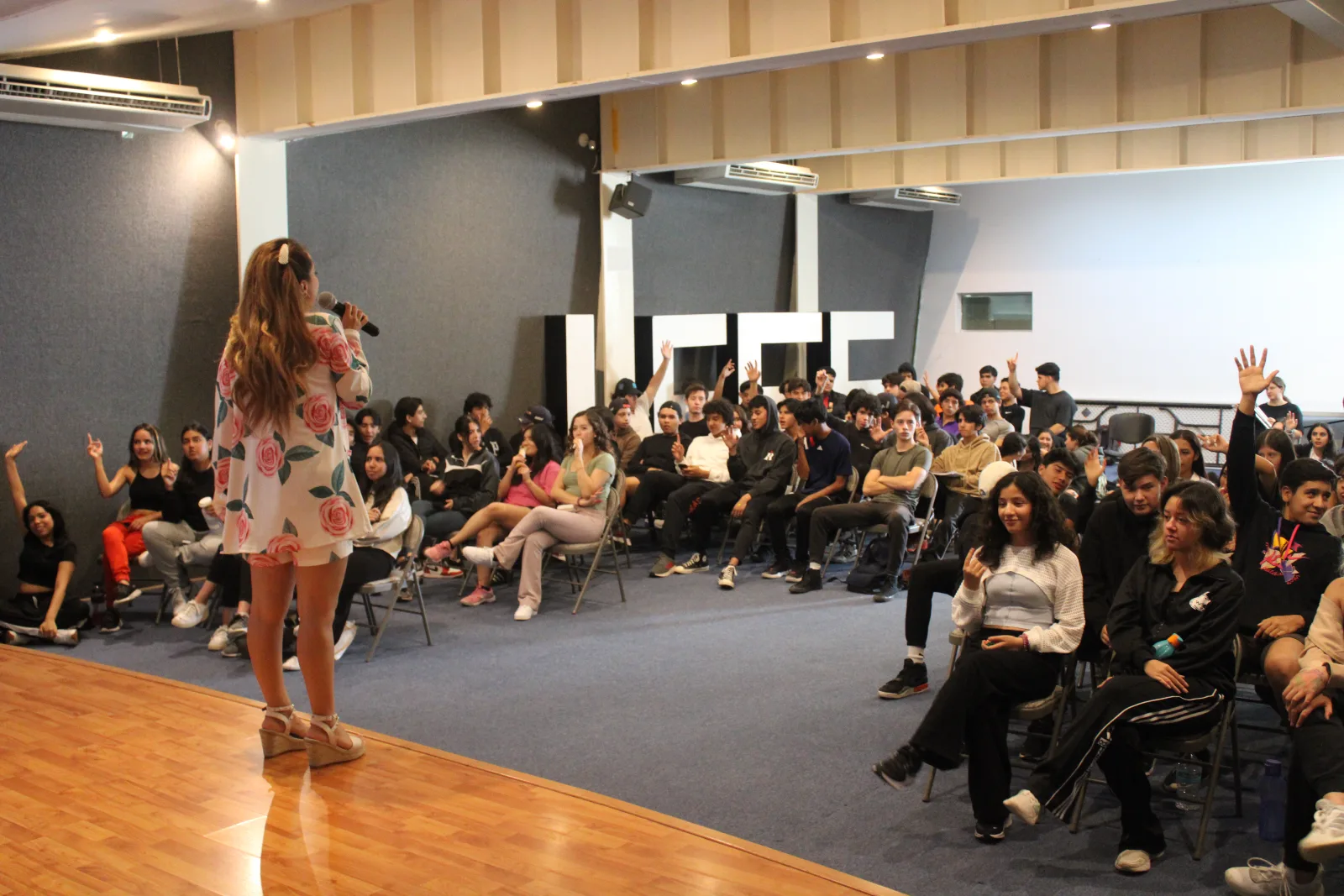 Alumnos participando en una conferencia en el auditorio