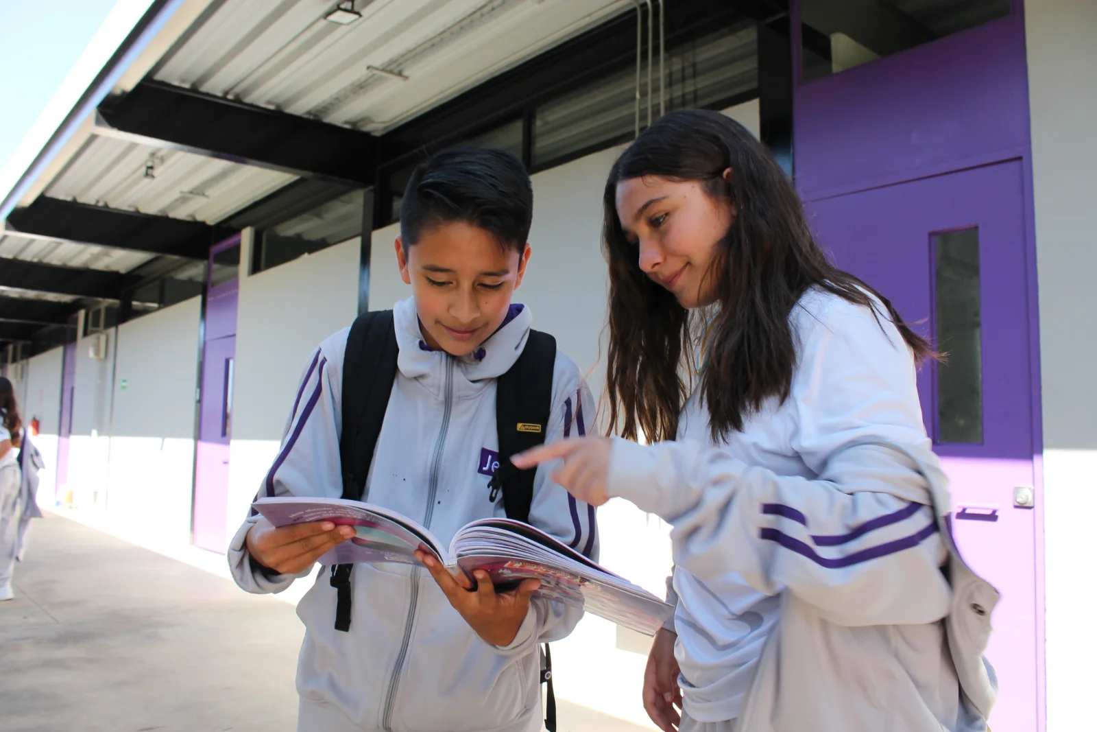Dos alumnos leyendo en un pasillo del campus